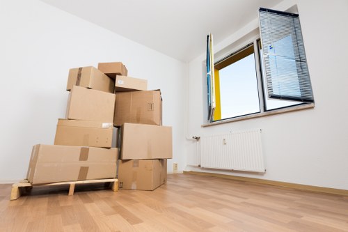 Movers carrying furniture through a residential staircase in Archway